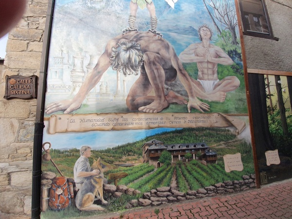 Day 21: Wall painting in Cacabelos. The text says: "Humanity is suffering from its uncontrolled progress