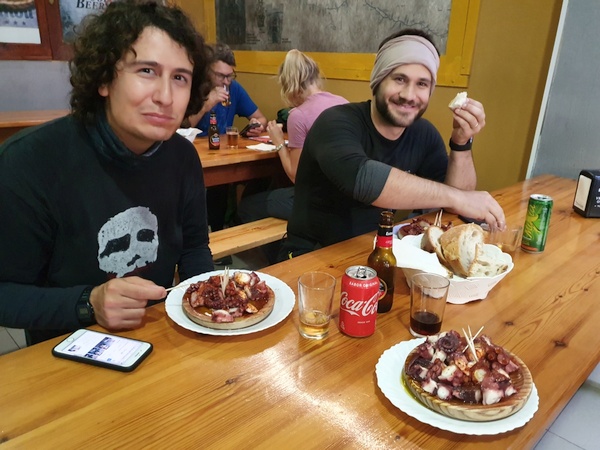 Italian Elia and American Landon from New Orleans having octopus in Furelos.